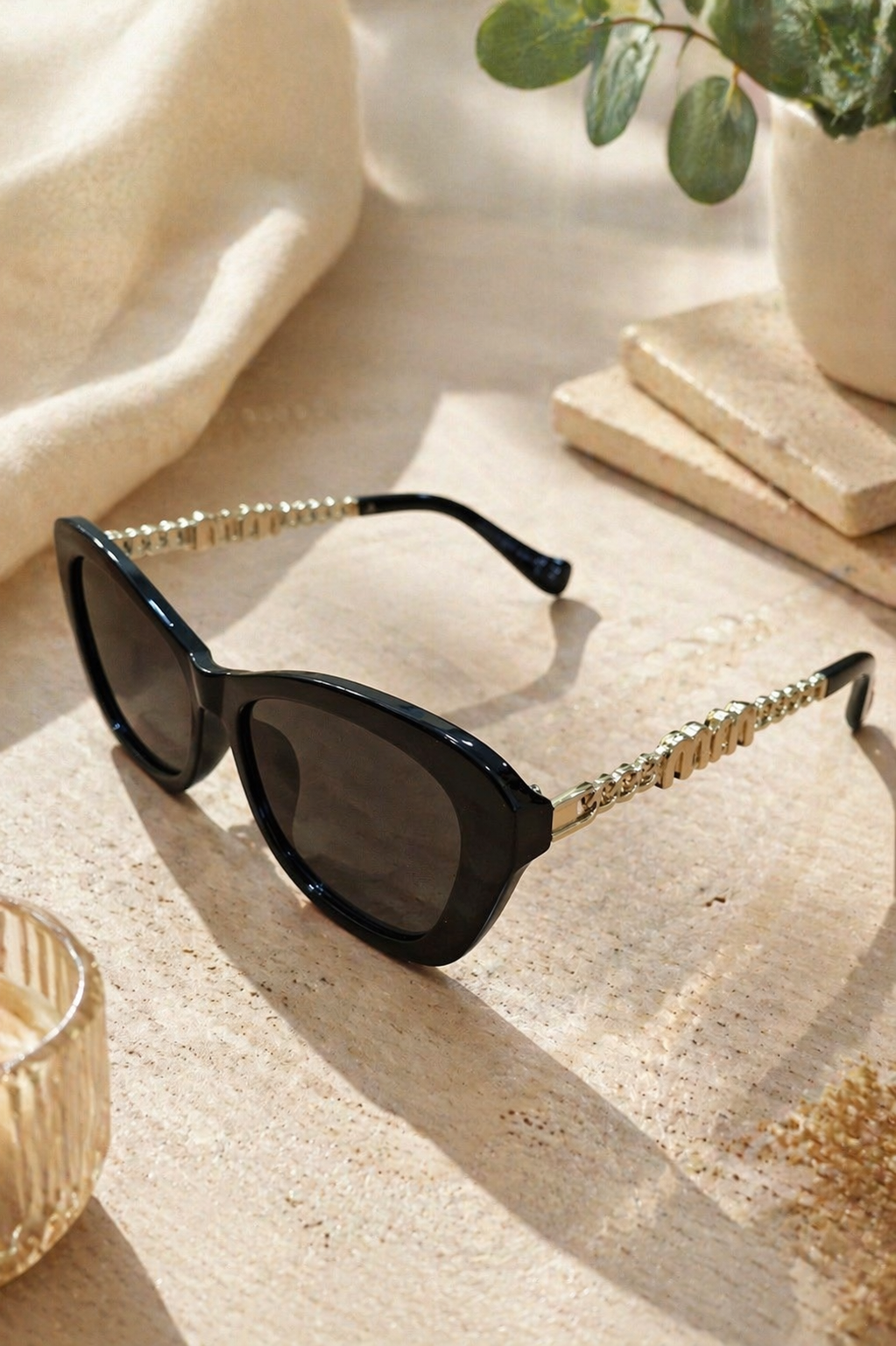 Gafas de sol negras con detalle dorado