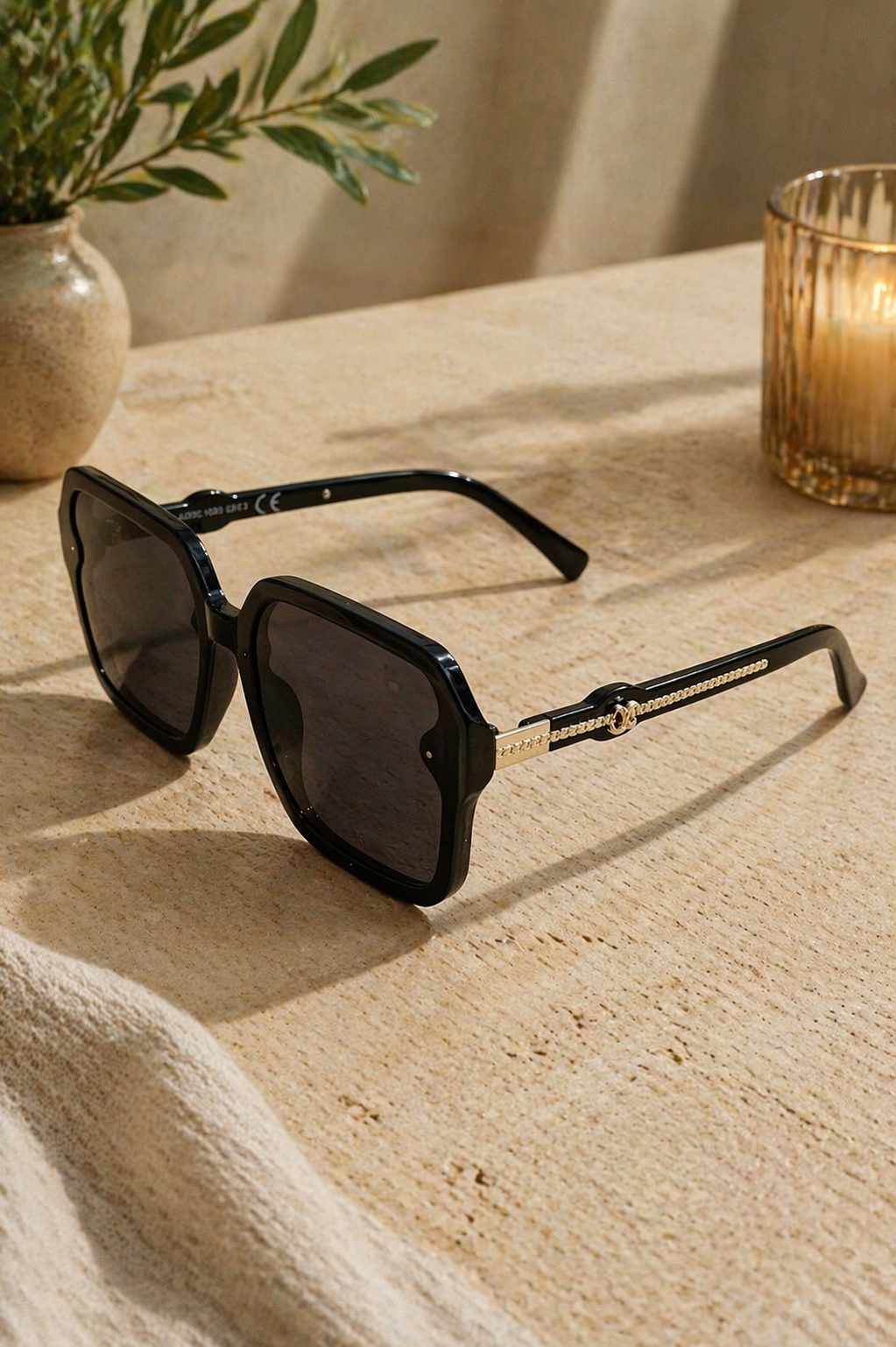 Gafas de sol negras cuadradas con detalle dorado