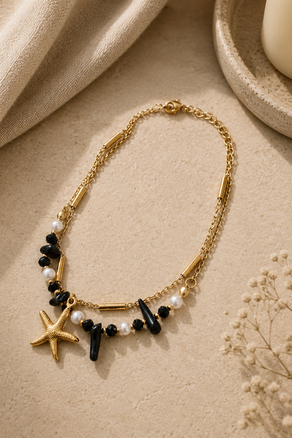 Tobillera con estrella de mar dorada y cuentas negras